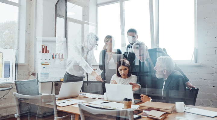 Team in ufficio che collabora vicino ad una scrivania