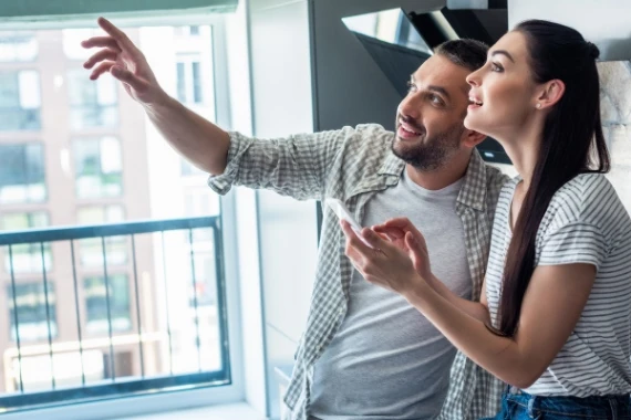 a couple with smartphone controls air conditioner system