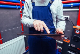 Man with tablet checks smart boiler connection
