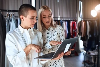 dama con tableta muestra la ropa en su boutique