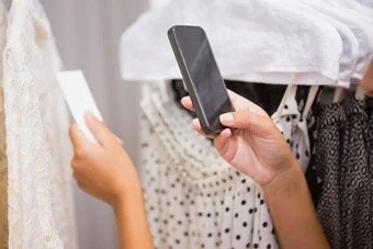 girl scans barcode of a product in the store with smartphone